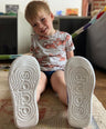 boy showing soles of recycled sustainable trainers