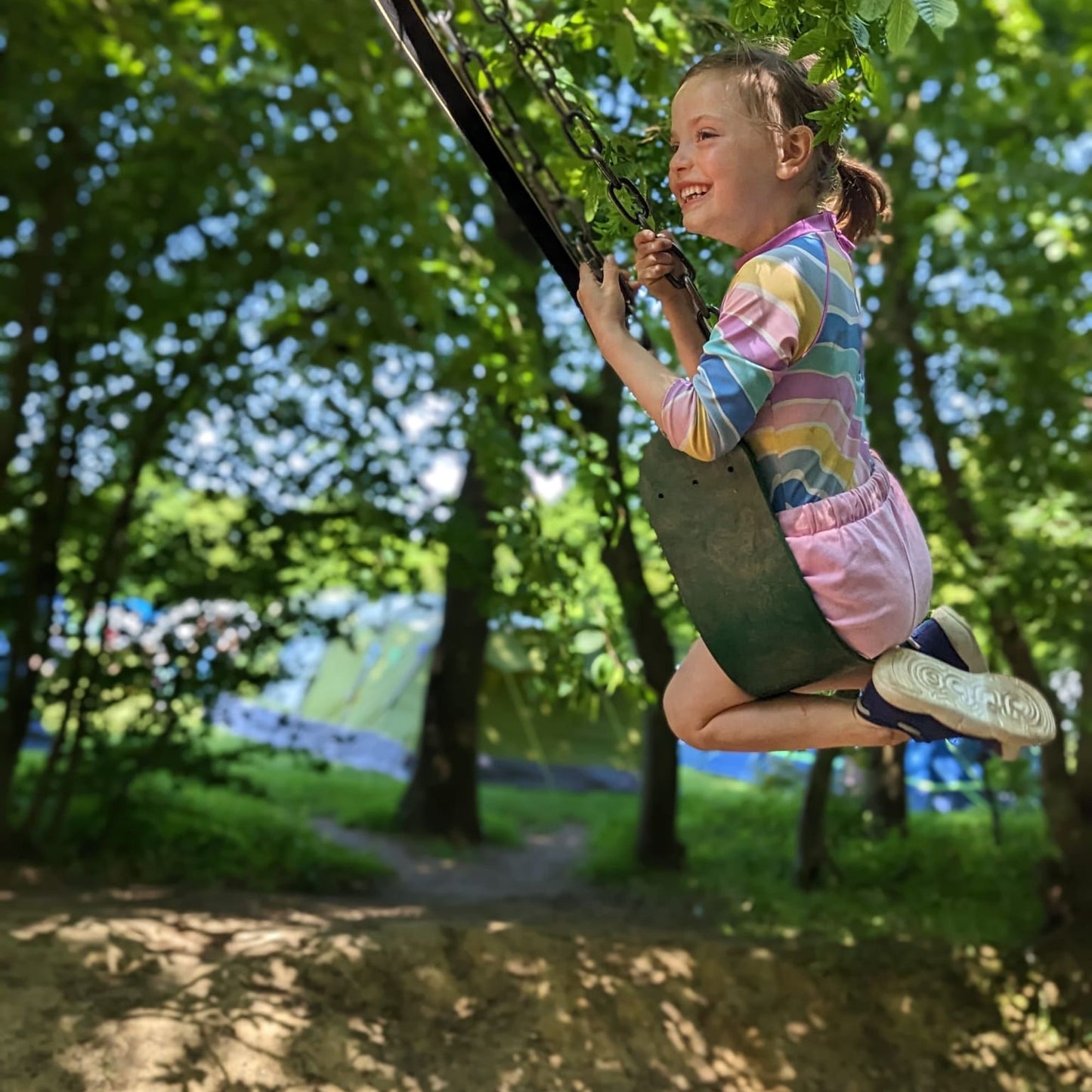 child wearing navy lightweight recycled trainers on swing