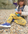 child wearing machine washable trainers on the beach