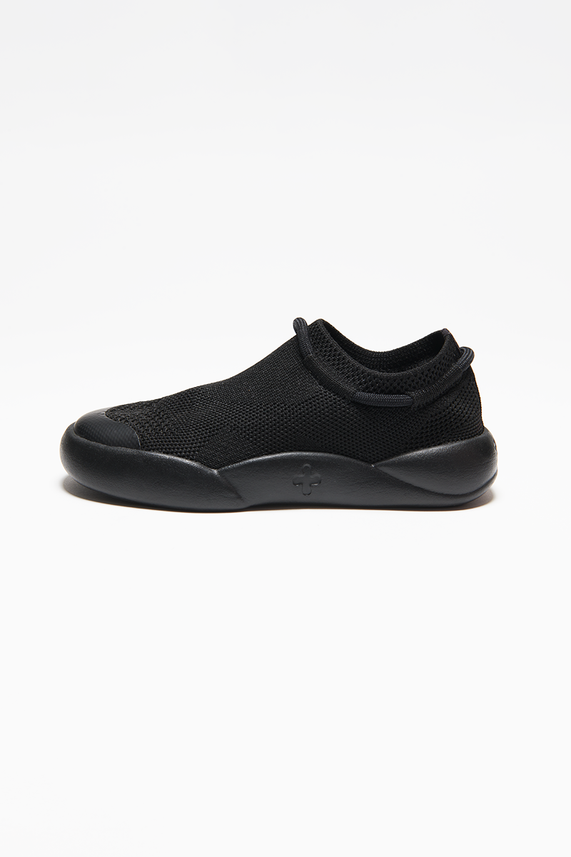black childrens trainers made from recycled plastic sugar cane sole side view